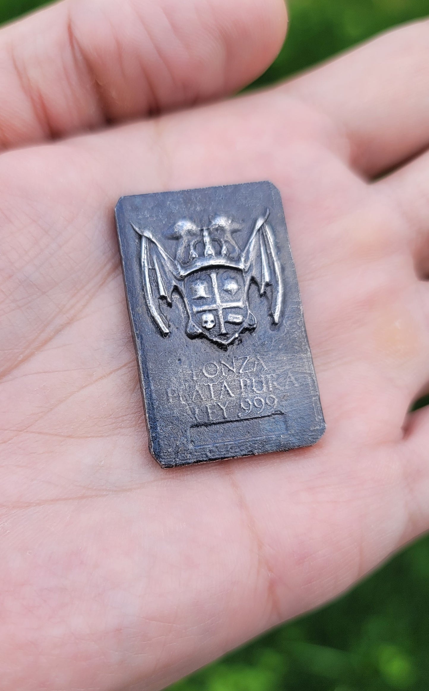 Coat of Arms Relic Bar in 1 oz .999 fine silver held in hand for scale, showing the winged Kannibal Hektor crest
