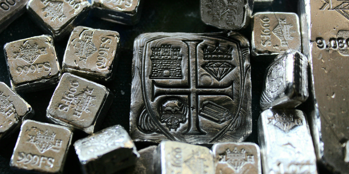 Kannibal Hektor Coat of Arms Crest in 2 oz .999 fine silver, displayed among smaller hand-cast silver bars and fractional pieces