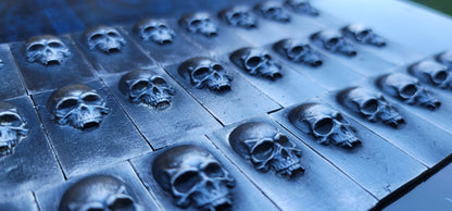 Group of 2025 Kannibal Skull Bars in .999 fine silver, arranged in rows with sculpted skull relief