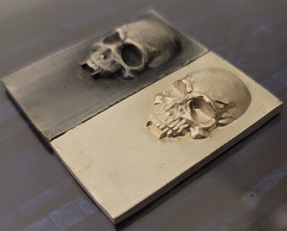 Angled view of 2025 Kannibal Skull Bars in antique and matte finishes, showing raised skull relief in 1 oz .999 fine silver