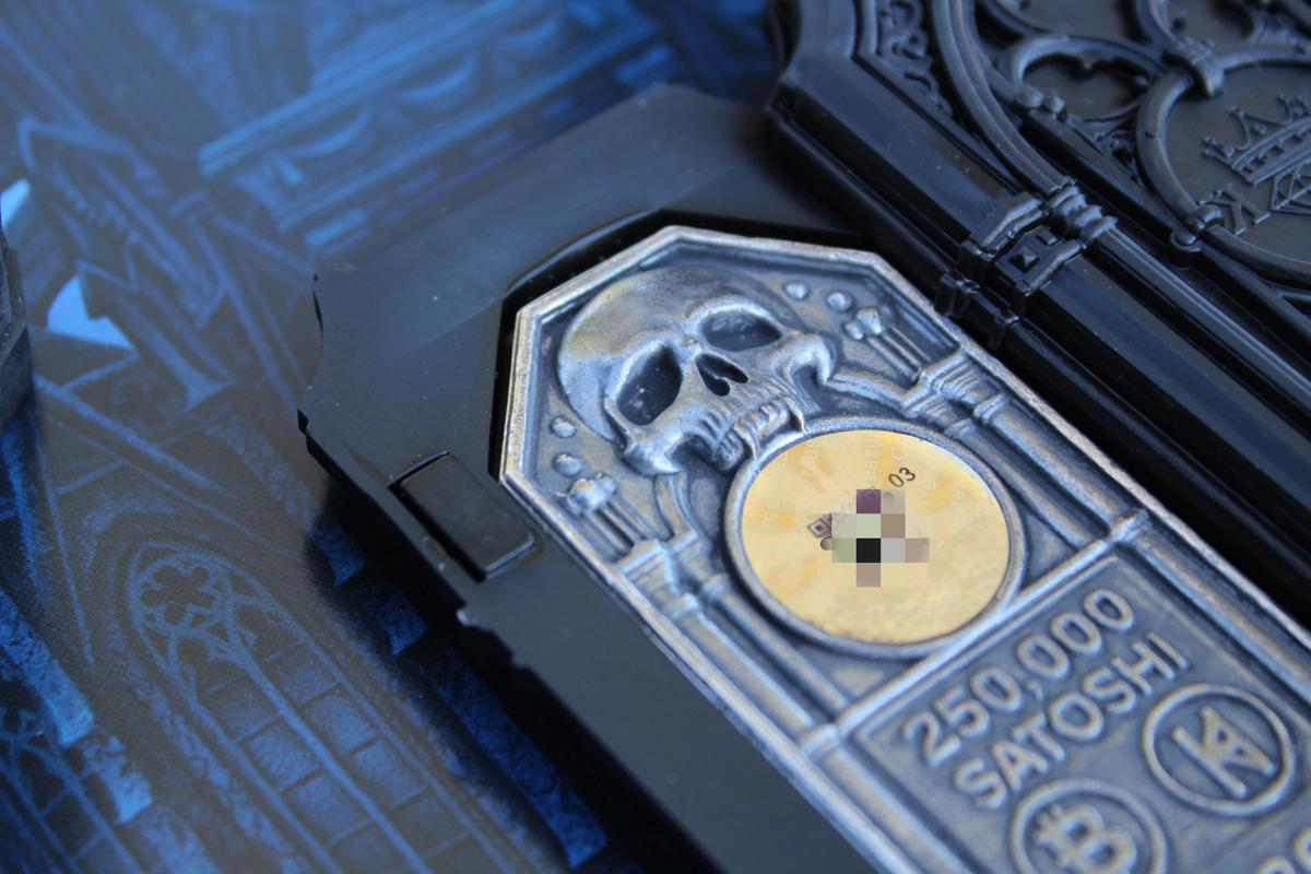 Close-up of The Reliquary 2 oz .999 fine silver Bitcoin wallet with skull relief, hologram, and 250,000 Satoshi inscription