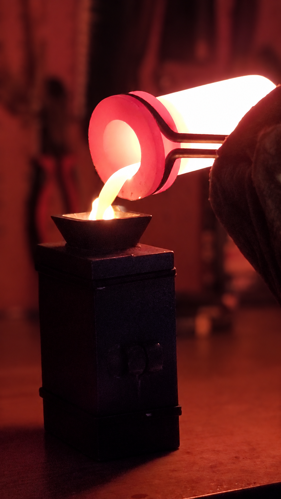 Molten silver being poured from a glowing crucible into a mold during the Kannibal Hektor hand-casting process