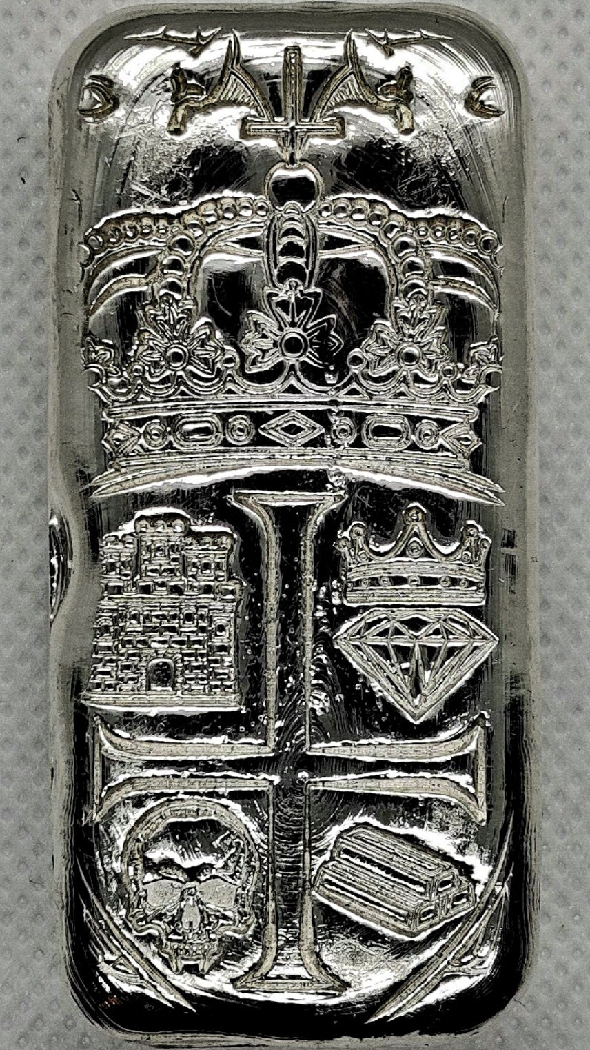 Front of Partial Coat of Arms Crest Bar in .999 fine silver, showing crown, castle, crowned diamond, skull, and bullion bar heraldic design