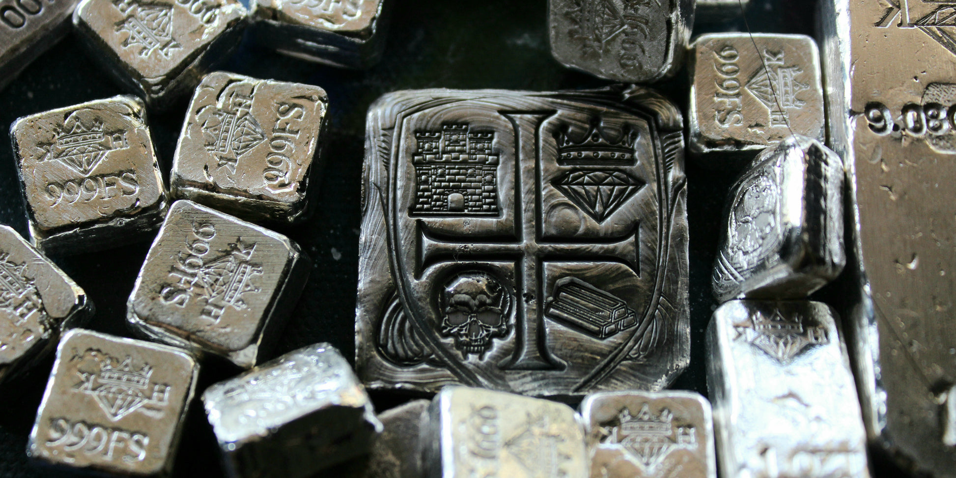 Kannibal Hektor Coat of Arms Crest in 2 oz .999 fine silver, displayed among smaller hand-cast silver bars and fractional pieces