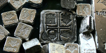 Kannibal Hektor Coat of Arms Crest in 2 oz .999 fine silver, displayed among smaller hand-cast silver bars and fractional pieces