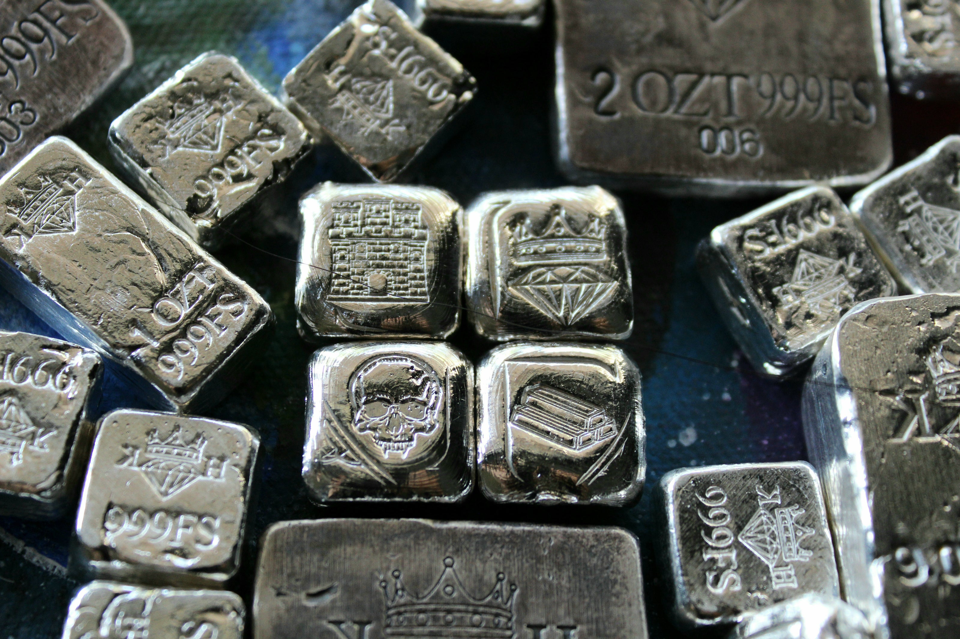 Kannibal Crest Pieces Fractional Set V.1 displayed among other hand-cast .999 fine silver bars, showing castle, crowned diamond, skull, and bullion designs