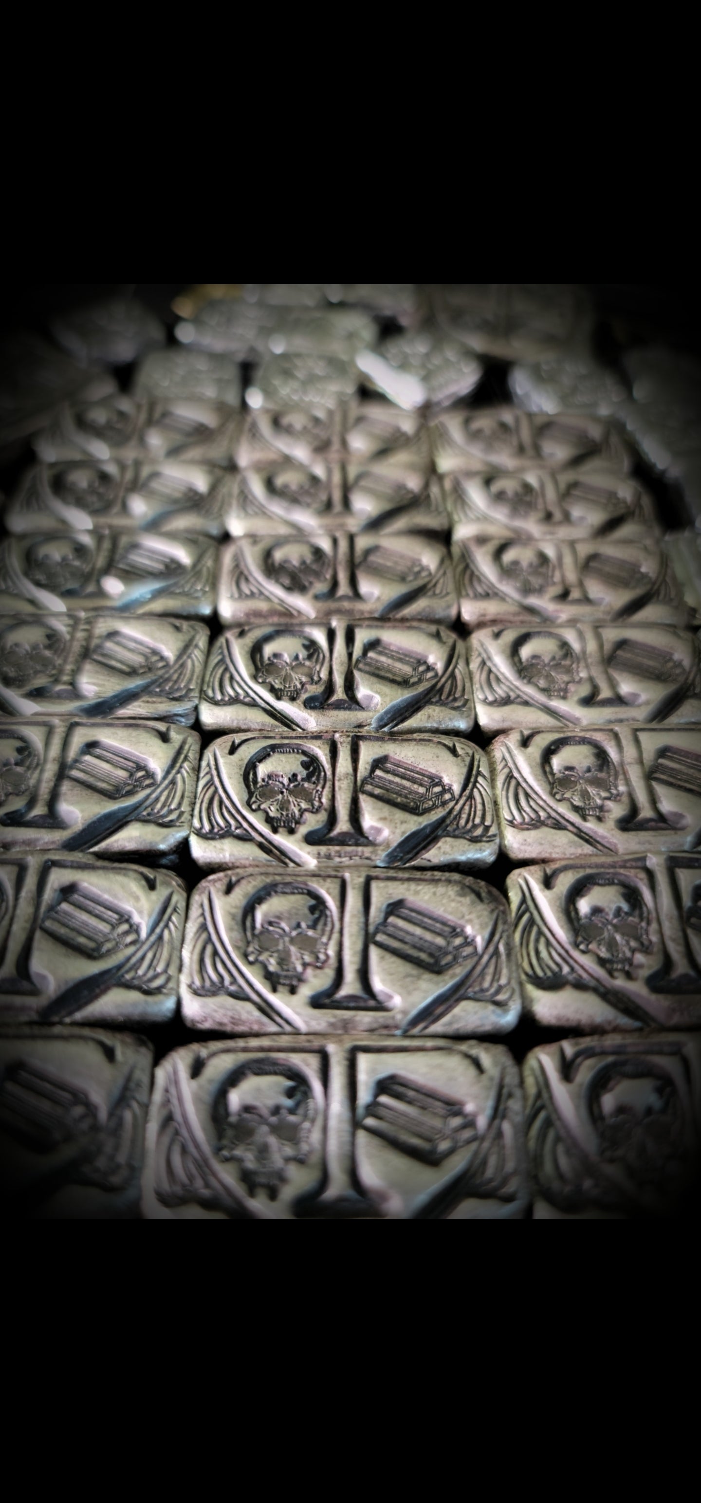 Group of Trials/Treasure Bars in .999 fine silver, arranged in rows with repeated skull and bullion bar designs