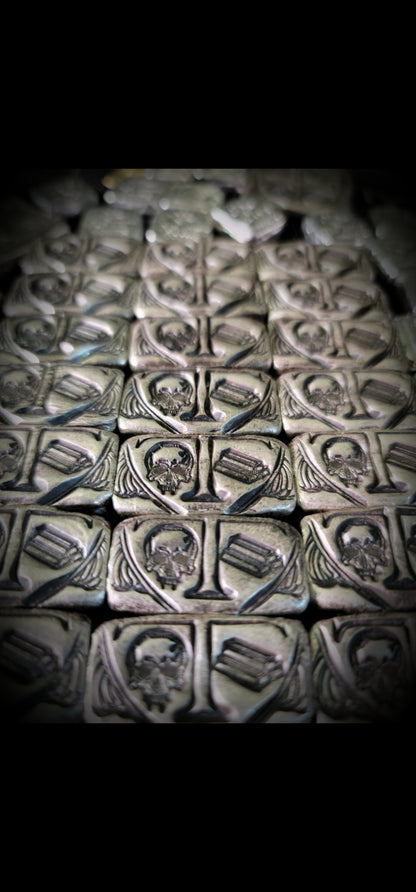 Group of Trials/Treasure Bars in .999 fine silver, arranged in rows with repeated skull and bullion bar designs