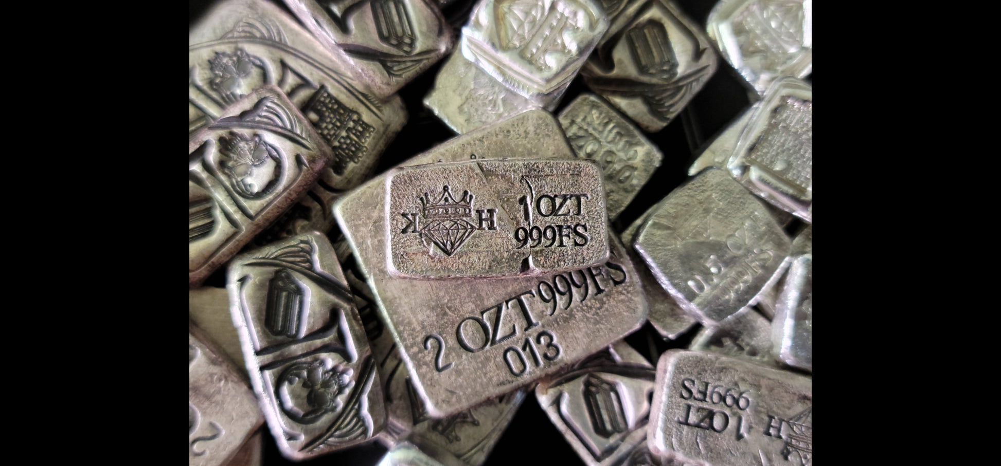 Reverse of 1 oz Trials/Treasure Bar in .999 fine silver resting on the reverse of a 2 oz Kannibal Hektor Crest Bar