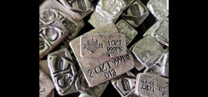 Reverse of 1 oz Trials/Treasure Bar in .999 fine silver resting on the reverse of a 2 oz Kannibal Hektor Crest Bar