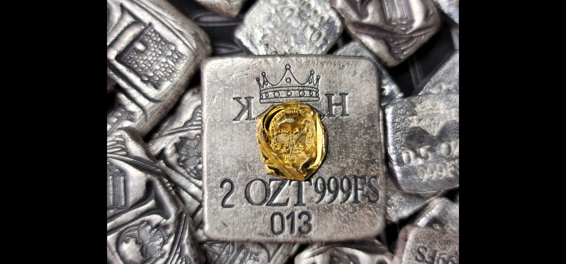Kannibal Crest Gold Fractional in 2.7 grams of .999 fine gold, shown resting on the reverse of a 2 oz Kannibal Hektor Crest Bar